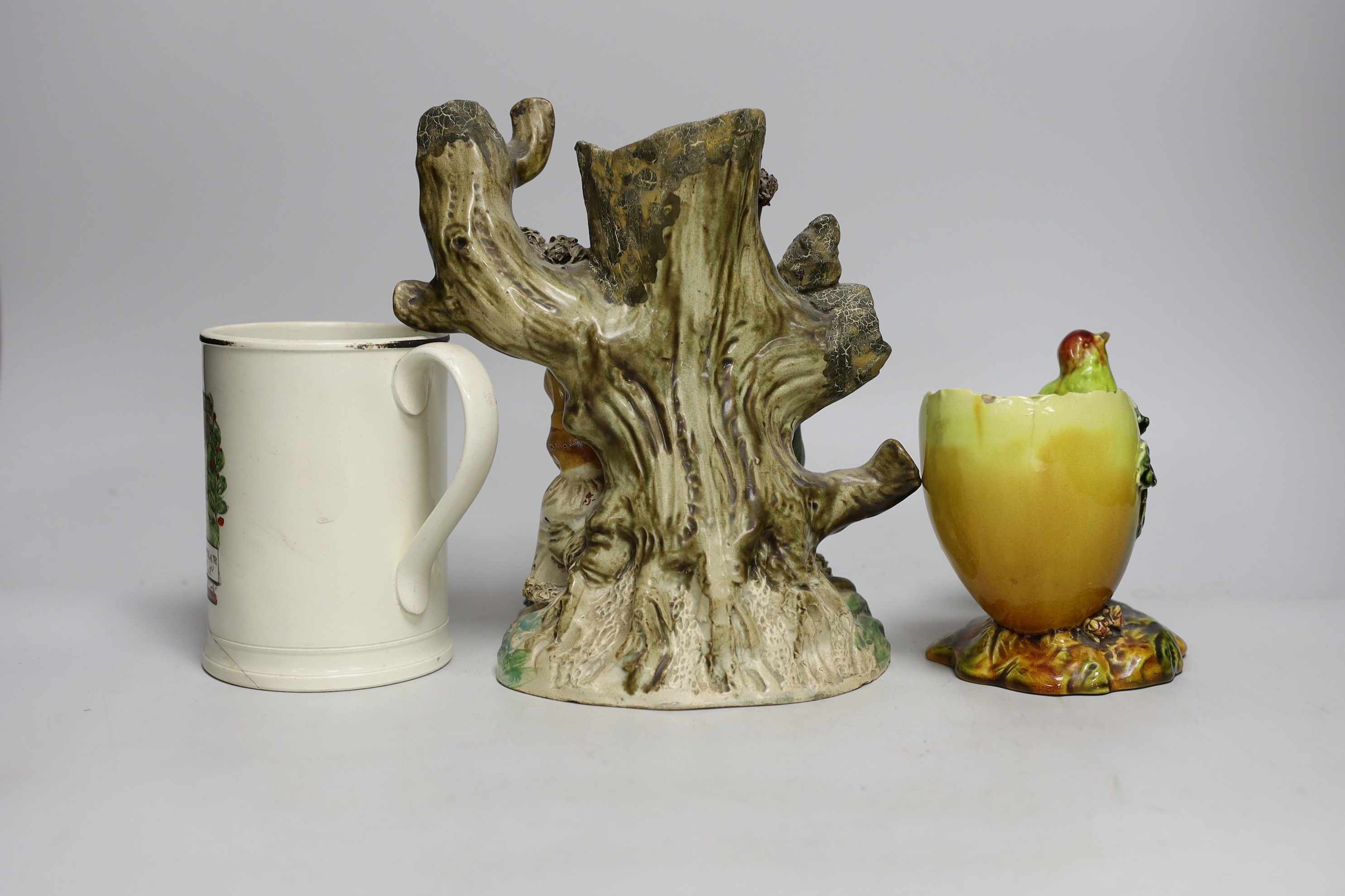 An early Staffordshire figure group, a Bretby egg shaped vase and a 19th century Iron Bridge frog tankard, figure group 24cms high